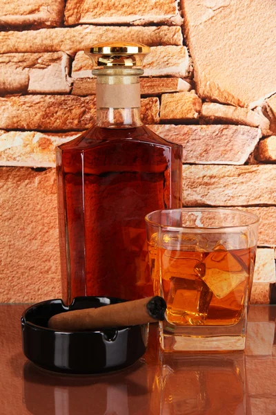 Μπουκάλι και ποτήρι ουίσκι και πούρα στο τούβλο τοίχων φόντο — Φωτογραφία Αρχείου