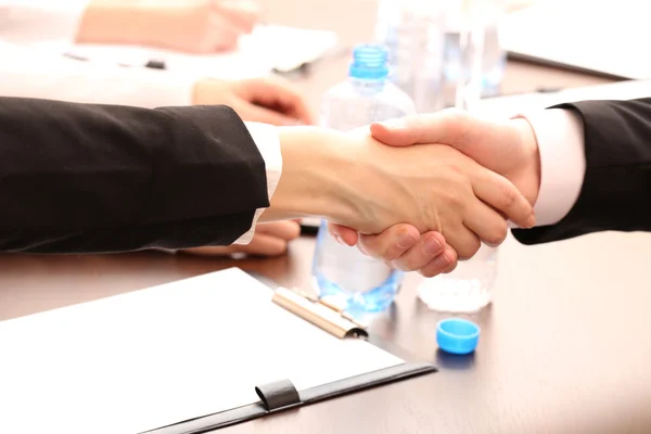 Negocios estrechando las manos, en el fondo de la oficina — Foto de Stock
