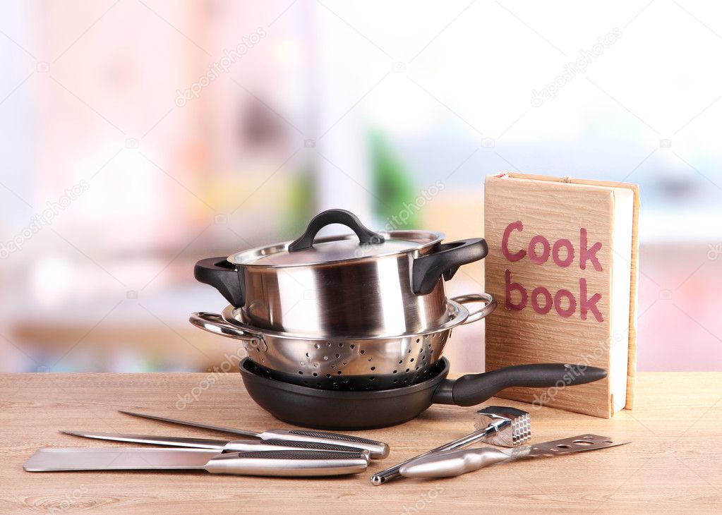 composition of kitchen tools and cook book on table in kitchen