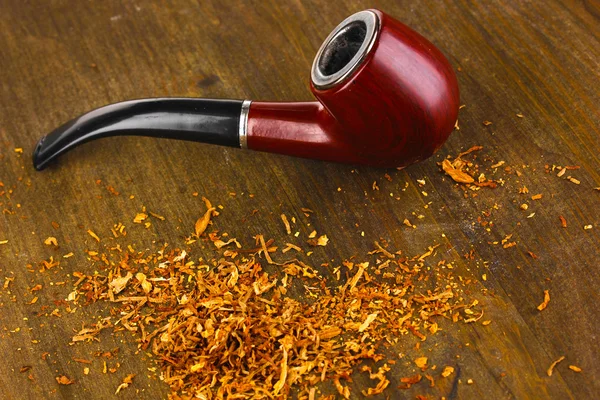 Smoking pipe and tobacco on wooden table close-up — Stock Photo, Image