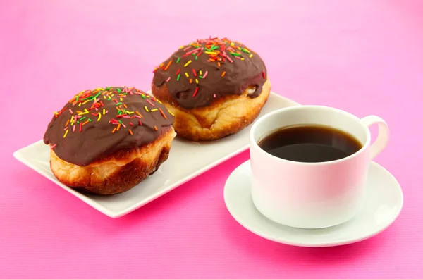 Tasty donuts on color plate on color background — Stock Photo, Image