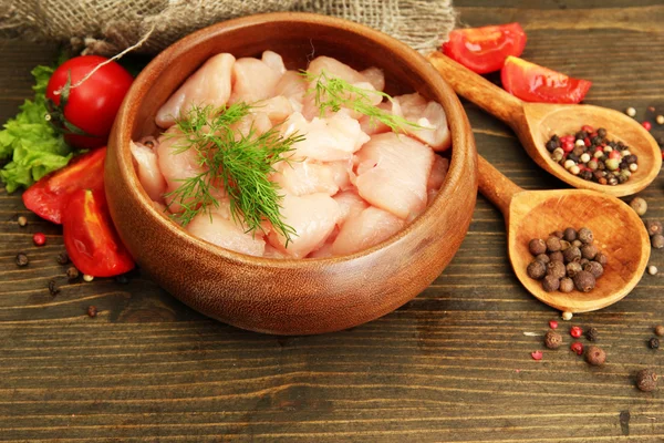 Carne di pollo cruda in ciotola, su fondo di legno — Foto Stock