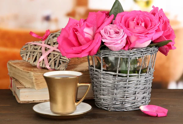 Mooie roze rozen in vaas op houten tafel op kamer achtergrond — Stockfoto