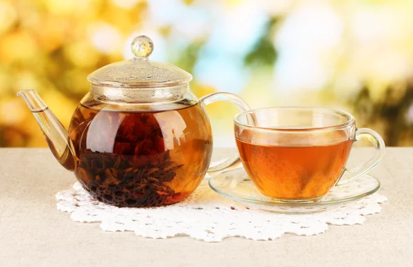 Екзотичний зелений чай з квітами в скляному чайнику на яскравому фоні — стокове фото