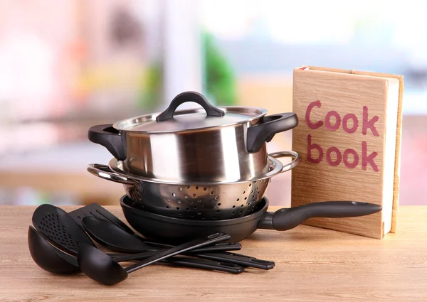 Composition of kitchen tools and cook book on table in kitchen — Stock Photo, Image