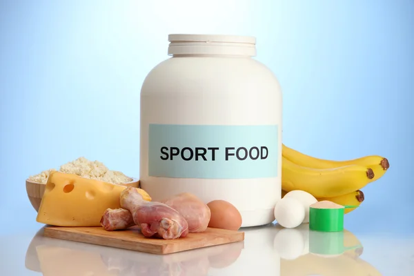 Jar of protein powder and food with protein, on blue background — Stock Photo, Image