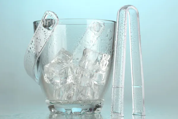 Glass ice bucket on light blue background — Stock Photo, Image