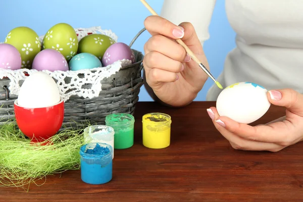 Genç kadın Paskalya yumurtaları, renkli arka plan üzerinde boyama — Stok fotoğraf