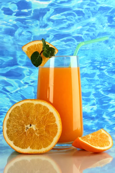 Copo de suco de laranja com hortelã e laranja no fundo do mar — Fotografia de Stock