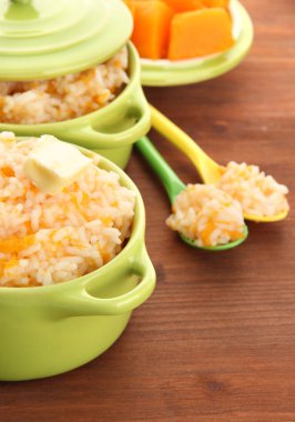 Tat pirinç lapası kabak ahşap arka plan üzerinde tencere ile