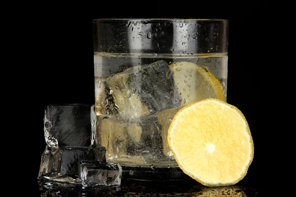 Ice cubes in glass with lemon isolated on black — Stock Photo, Image