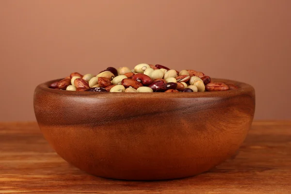 木碗豆棕色背景上的木桌上 — 图库照片