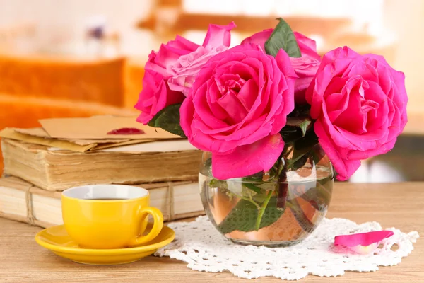 Hermosas rosas rosadas en jarrón sobre mesa de madera sobre fondo de habitación —  Fotos de Stock