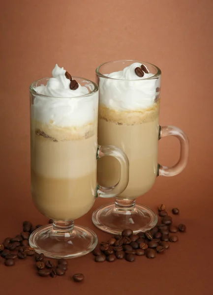 Café con leche fragante en vasos, sobre fondo marrón — Foto de Stock