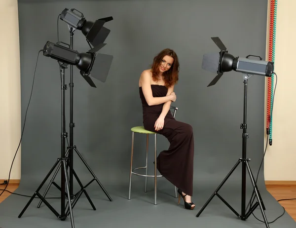 Beautiful professional female model resting between shots in photography studio shoot set-up — Stock Photo, Image