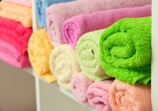 Colorful towels on shelves in bathroom — Stock Photo, Image