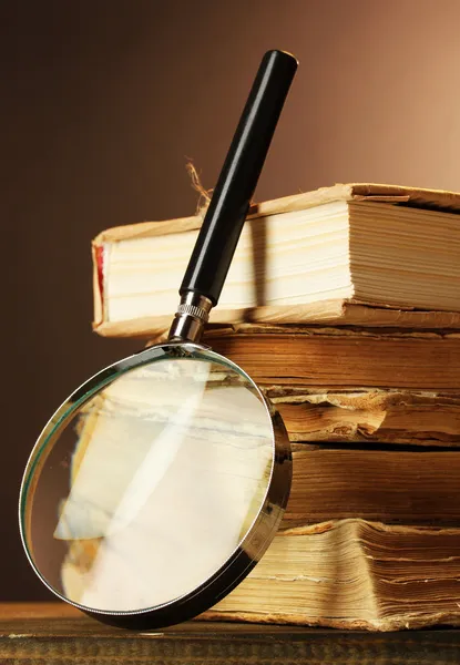 Lupa e livros na mesa — Fotografia de Stock