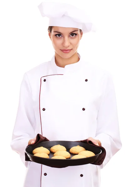 Portrait of young woman chef with cakes on dripping pan isolated on white — Stock Photo, Image