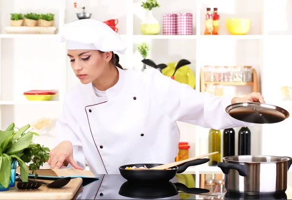 Jonge vrouw chef-kok koken in de keuken — Stockfoto