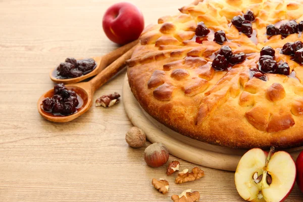 Smakelijk zelfgemaakte taart met jam en appels, op houten tafel — Stockfoto