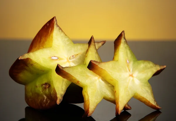 Dois carambolas maduros no fundo amarelo — Fotografia de Stock