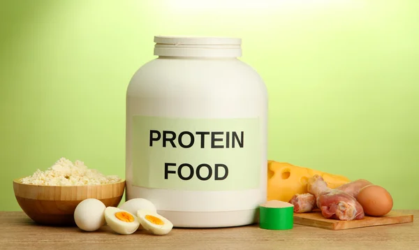 Frasco de proteína en polvo y alimentos con proteína, sobre fondo verde —  Fotos de Stock