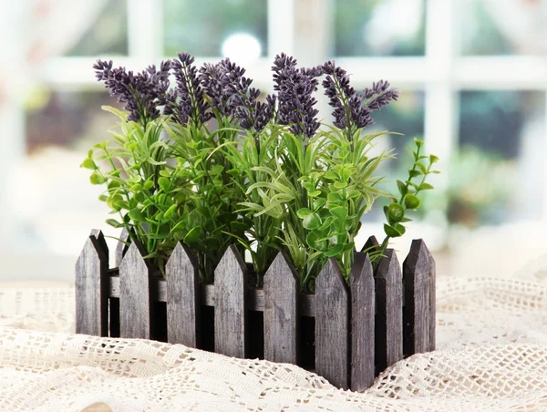 Lavanda decorativa em caixa de madeira na mesa de madeira no fundo da janela — Fotografia de Stock