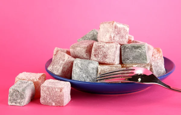 Rahat lokum in piatto con forchetta su fondo rosa — Foto Stock