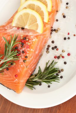 bitkiler ve ahşap zemin üzerinde plaka üzerinde limon dilimleri ile taze somon fileto