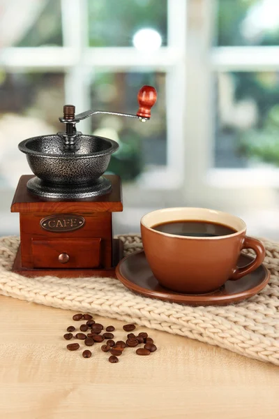 Tasse de café avec écharpe sur la table dans la chambre — Photo