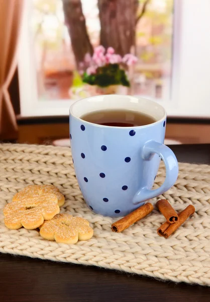 Cup of tea with scarf on table in room — Stock Photo, Image