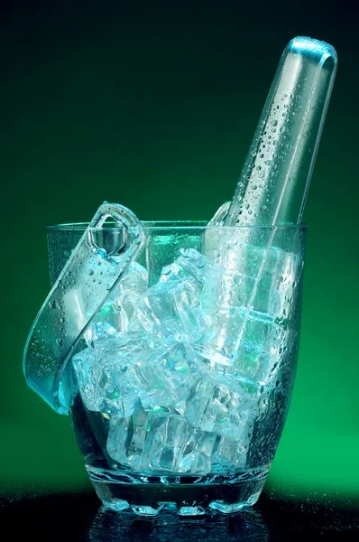 Glass ice bucket on dark green background — Stock Photo, Image