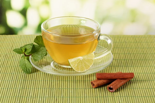 Taza de té con menta, lima y canela sobre la mesa sobre fondo brillante —  Fotos de Stock