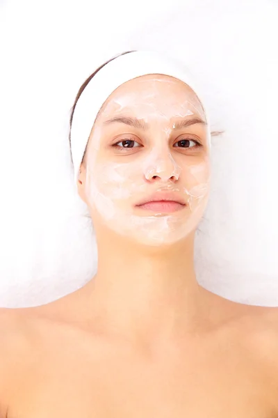 Jonge vrouw met romige gezichtsmasker — Stockfoto