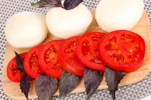 Mozzarella saporita con pomodori sul tagliere primo piano — Foto Stock