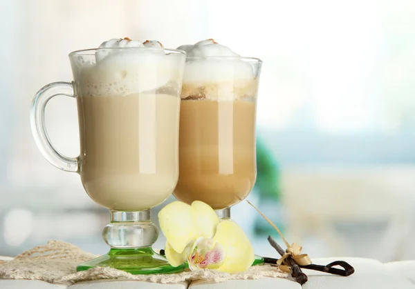 Fragrant coffee latte in glasses cups with spices, on wooden table — Stock Photo, Image