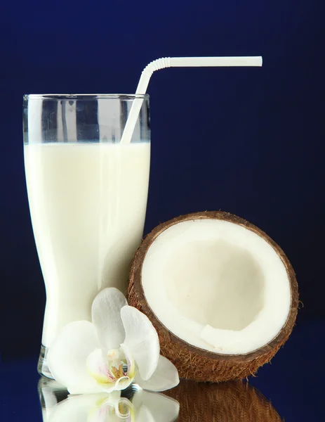 Noix de coco avec verre de lait, sur fond bleu — Photo