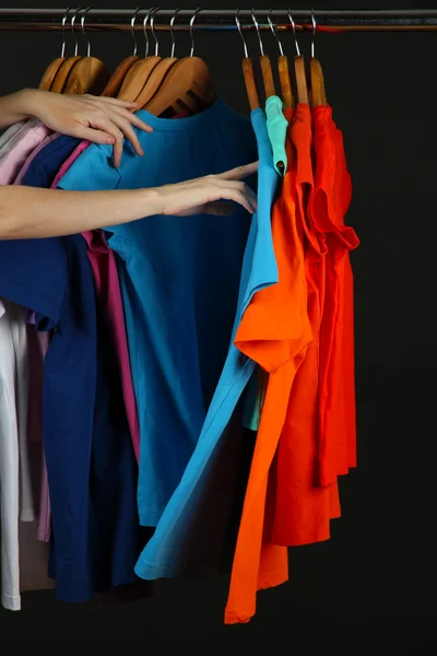 Variedade de camisas casuais em cabides de madeira, isolado em preto — Fotografia de Stock