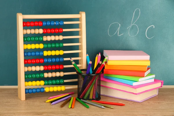 Juguete ábaco, libros y lápices en la mesa, en el fondo del escritorio de la escuela —  Fotos de Stock