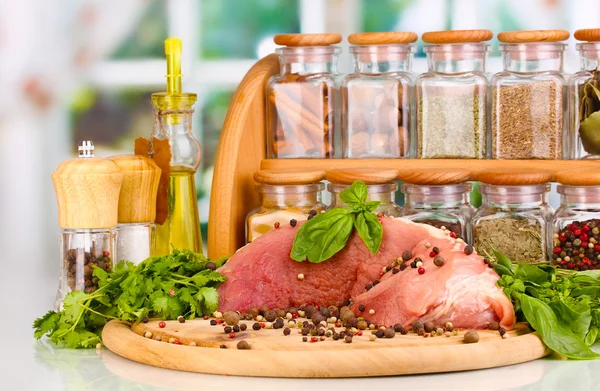 Un gran trozo de cerdo marinado con hierbas, especias y aceite de cocina a bordo sobre una mesa blanca sobre fondo de ventana —  Fotos de Stock