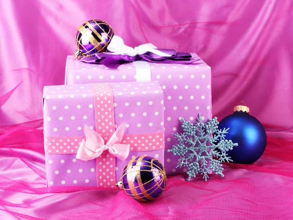 Hermosos regalos, bolas de Navidad y copo de nieve sobre un fondo rosa — Foto de Stock