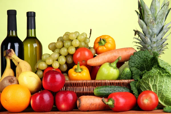 Kompozycja z warzyw i owoców w wiklinowym koszu na zielonym tle — Zdjęcie stockowe