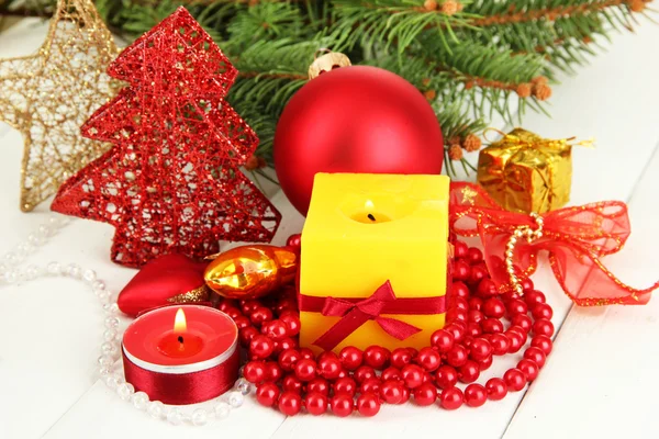 Yellow candle with christmas decoration on light background — Stock Photo, Image