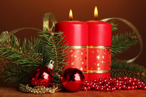 Two candles and christmas decorations, on brown background — Stock Photo, Image