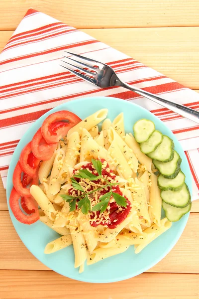 Rigatoni pasta dish with tomato sauce on wooden table — Stock Photo, Image