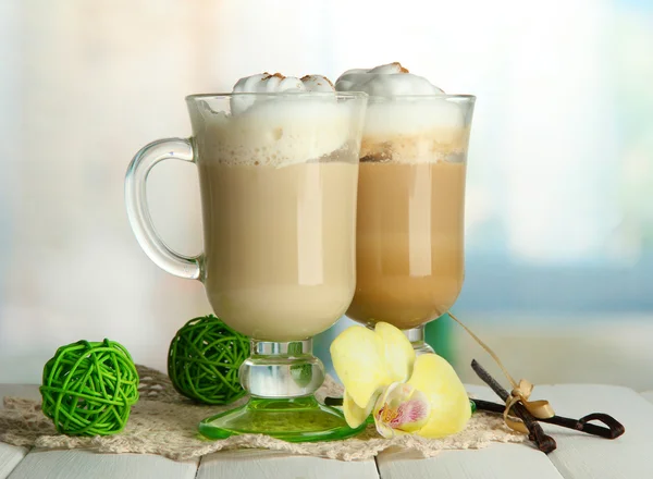 Latte de café perfumado em copos copos com especiarias, na mesa de madeira — Fotografia de Stock