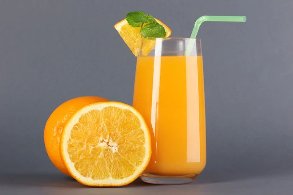 Glas apelsinjuice med mynta och orange på grå bakgrund — Stockfoto