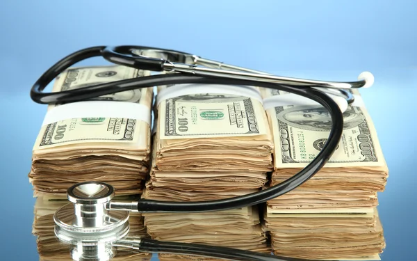 Concetto di costo sanitario: stetoscopio e dollari su sfondo a colori Foto Stock