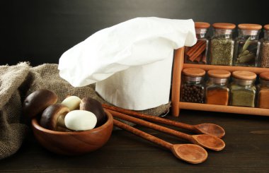 Şef'in şapkası ve kitchenwear tabloda gri arka plan üzerinde kompozisyonu