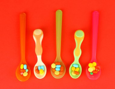 plastik kaşık kırmızı arka plan rengi hapları ile